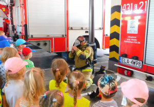 Strażak demonstruje dzieciom maskę tlenową