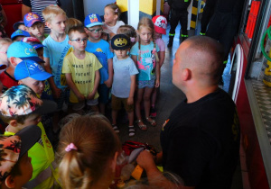 Dzieci z zainteresowaniem słuchają strażaka