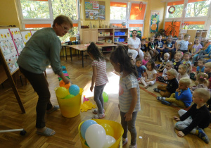 Ewelinka i Emilka z grupy Żabek sprawdzają czy trzylatki dobrze posegregowały balonowe buźki.