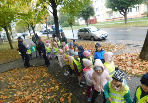 Dzieci przed przedszkolem w towarzystwie policji.