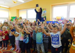 Przedszkolaki, zachęcone wesołą melodią, machają rękoma i śpiewają piosenkę pt. "Rumiane jabłuszko".