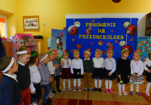 Przedszkolaki śpiewają piosenkę pt. "Jabłuszko rumiane" i wystukują rytm na grzechotce.