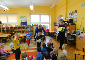 Dzieci podczas zabawy pt. "Kolory". Wstały przedszkolaki, które mają ubranie w kolorze żółtym.