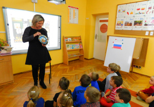 Pani Ania pokazuje dzieciom pamiątkę z Rosji - talerz, na którym namalowana jest cerkiew.