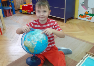 Fabian pokazuje na globusie jakim wielkim krajem jest Rosja.