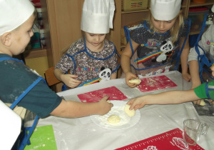 Lena, Oskar, Wojtek, Zuzia układają na talerzu wykonane syrniczki.