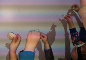 Dzieci prezentują efekty lania wosku na tablicy.