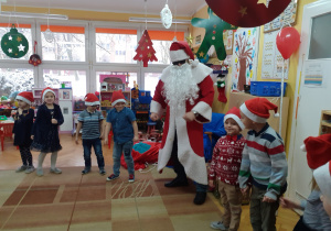 Mikołaj tańczy z dziećmi świątecznego twista.