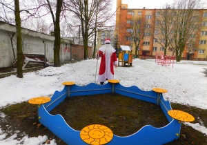 Mikołaj z obdarowaną piaskownicą w ogrodzie przedszkolnym.