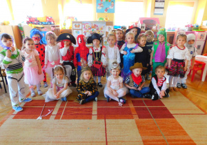 Dzieci z grupy Biedronek prezentują się w barwnych strojach.