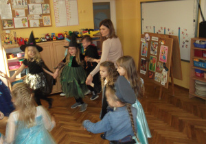 Dzieci tańczą w kole z panią Kamilą.