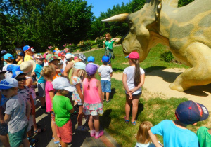Dzieci oglądają naturalnej wielkości figury dinozaurów.