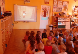 Dzieci oglądają bajkę „Przygody Rumcajsa”.