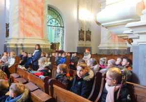 Dzieci z zaciekawieniem słuchają opowiadania o historii budowli z XVI w.