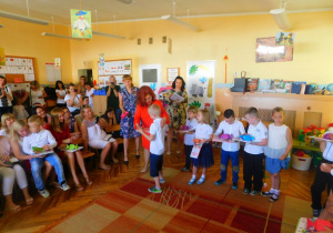 Pani Dyrektor wręcza chłopcu ze Słoneczek dyplom ukończenia przedszkola wraz z nagrodą książkową.