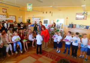 Pani Dyrektor wręcza chłopcu ze Słoneczek dyplom ukończenia przedszkola wraz z nagrodą książkową.