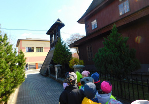 Dzieci zwiedzają kościół z zewnątrz.