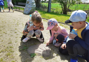 Ligia, Julka i Mateusz z „Krasnoludków” oglądają odcisk łapy dinozaura.