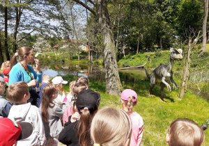Przedszkolaki słuchają informacji o rodzinie ciekawych dinozaurów.