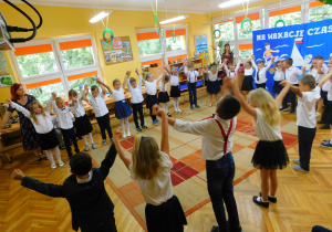 Koniec tańca – dzieci trzymają ręce w górze.