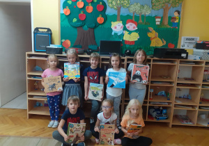 Dzieci z grupy „Krasnoludki” prezentują książki które otrzymały w nagrodę za zbieranie baterii.