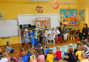 Pani Agnieszka z grupy Krasnoludków czyta wiersz "Rzepka", który przedstawiają dzieci.