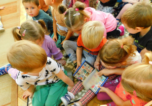 Dzieci oglądają klaser ze znaczkami.