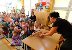 Pani Renata nagradza dzieci za dobrze wykonaną pracę.