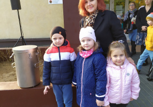 Pani dyrektor Barbara Nowakowska wraz z delegacją dzieci z Przedszkola nr 5 czyli: Gabrysią, Zosią i Filipem stoją obok Kapsuły Czasu .