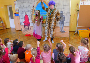 Tygrys z dziewczynką uprawiają gimnastykę.