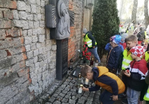 „Krasnoludki” zapalają znicze pod pomnikiem Ofiar Zbrodni Katyńskiej.
