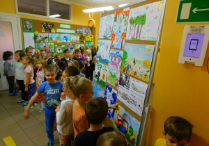 Przedszkolaki oglądają wystawę prac plastycznych.