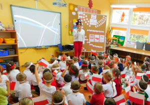 Pani Kamilka opowiada dzieciom o Narodowym Święcie Niepodległości.