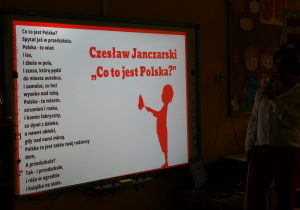 Pani Kamilka czyta dzieciom wiersz Czesława Janczarskiego "Co to jest Polska?"