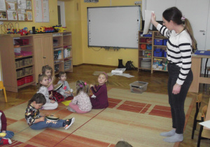 Pani Agnieszka pokazuje kolor kartki żółty – grają dziewczynki.