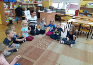 Dzieci naśladują ruchem prezentowany instrument.