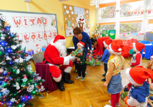Mikołaj wręcza prezent Jasiowi z grupy Misiaczków.