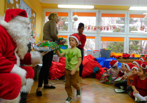 Mikołaj wręcza Frankowi z grupy Biedronek prezent.