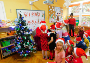 Dziewczynki z grupy Krasnoludków wręczają Mikołajowi obrazki.