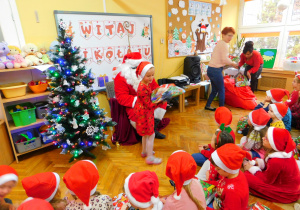 Mikołaj wręcza prezent Blance z grupy Krasnoludków.