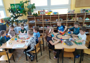 Dzieci z grupy Żabek bawią się przy stolikach nowymi zabawkami.