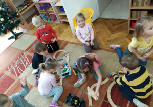Dzieci z grupy Misiaczków bawią się na dywanie nowymi zabawkami.