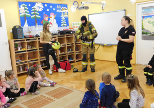 Dzieci oglądają ubiór strażaka.