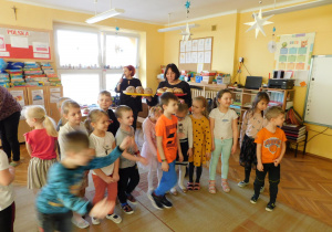 Pani Halinka częstuje dzieci z grupy "Krasnoludki" pączkami.