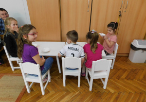 Karinka, Ligia, Michał, Gabrysia i Lena piją mleczko z miseczek.
