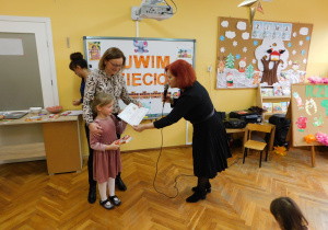 Pani Dyrektor wręcza dyplom i nagrodę Lence i jej mamie.