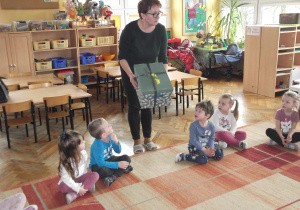 Pani Renia pokazuje dzieciom prezent od pani Wiosny.