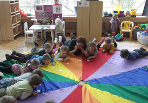 Dzieci dmuchają na papierowe krople deszczu.