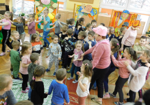 Dzieci prowadzone przez postacie występujące w bajce naśladują ruchem słowa piosenki.