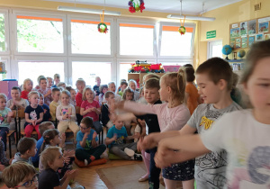 Przedszkolaki obserwują dzieci z grupy "Krasnoludki" podczas poloneza.